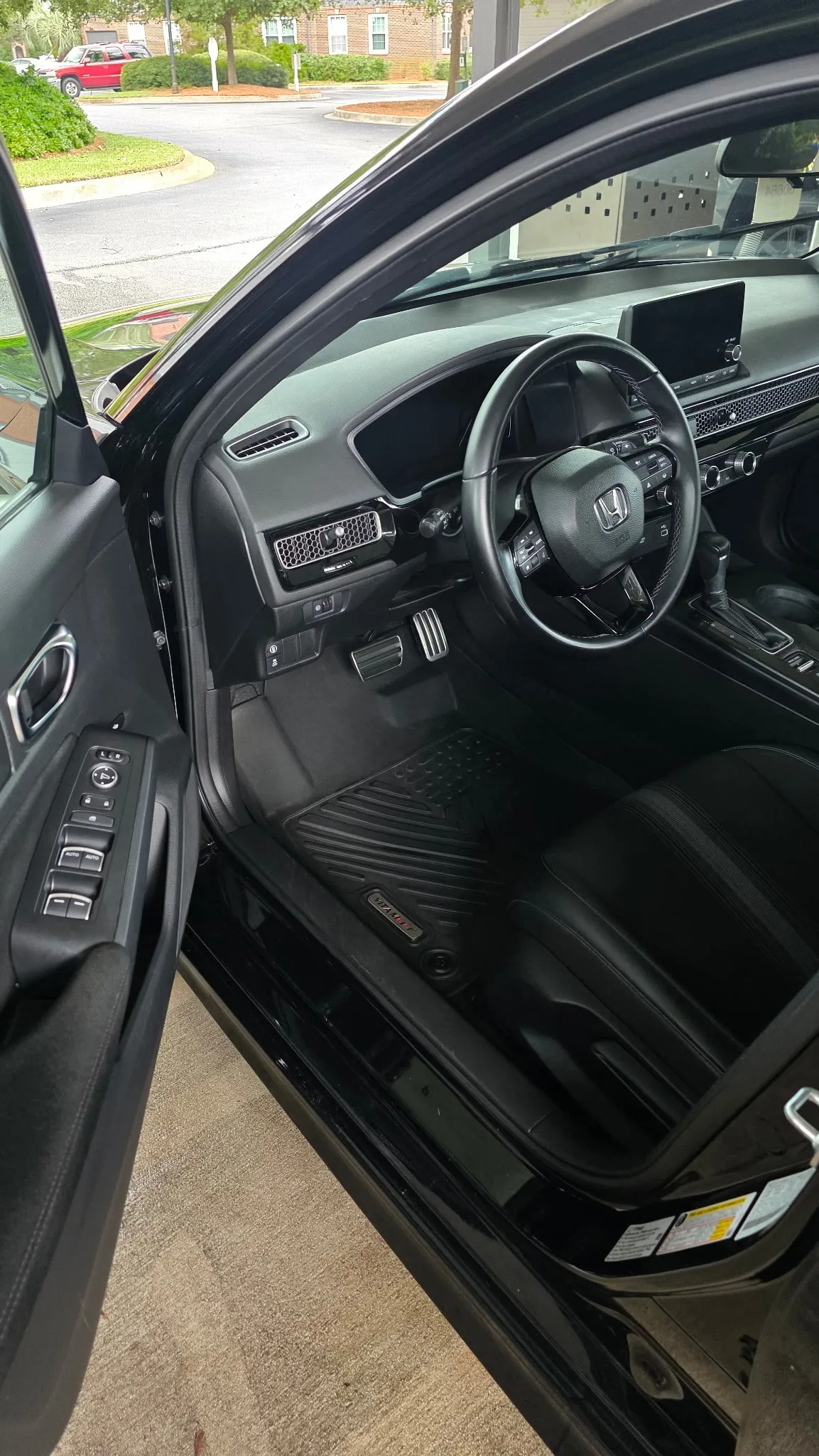 Front interior of a black Honda sedan with clean black leather seats and dashboard