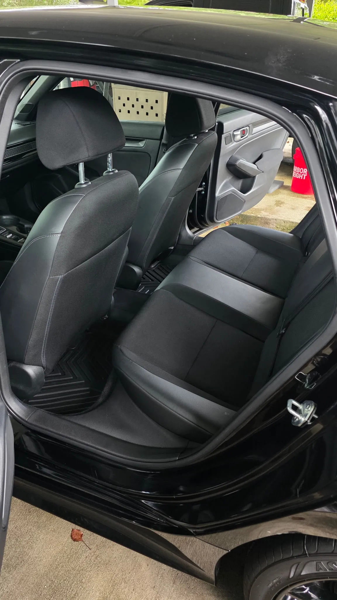 Rear seats of a black Honda sedan, leather cleaned with the door open
