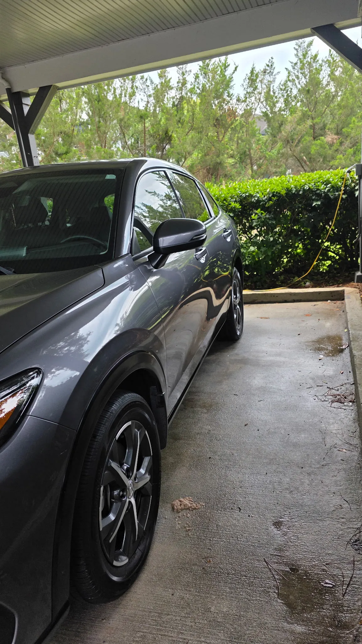 Grey crossover parked under a carport after an exterior detail