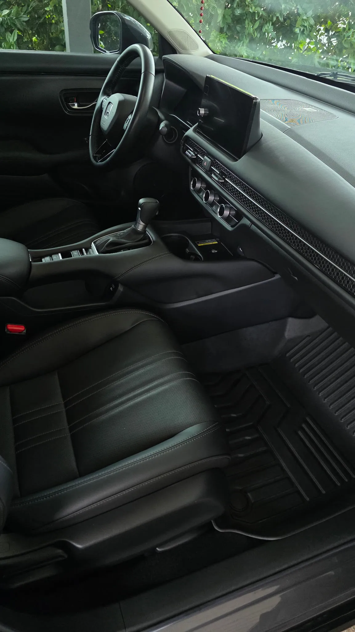Front interior of a grey crossover with clean leather seats and fitted floor mats