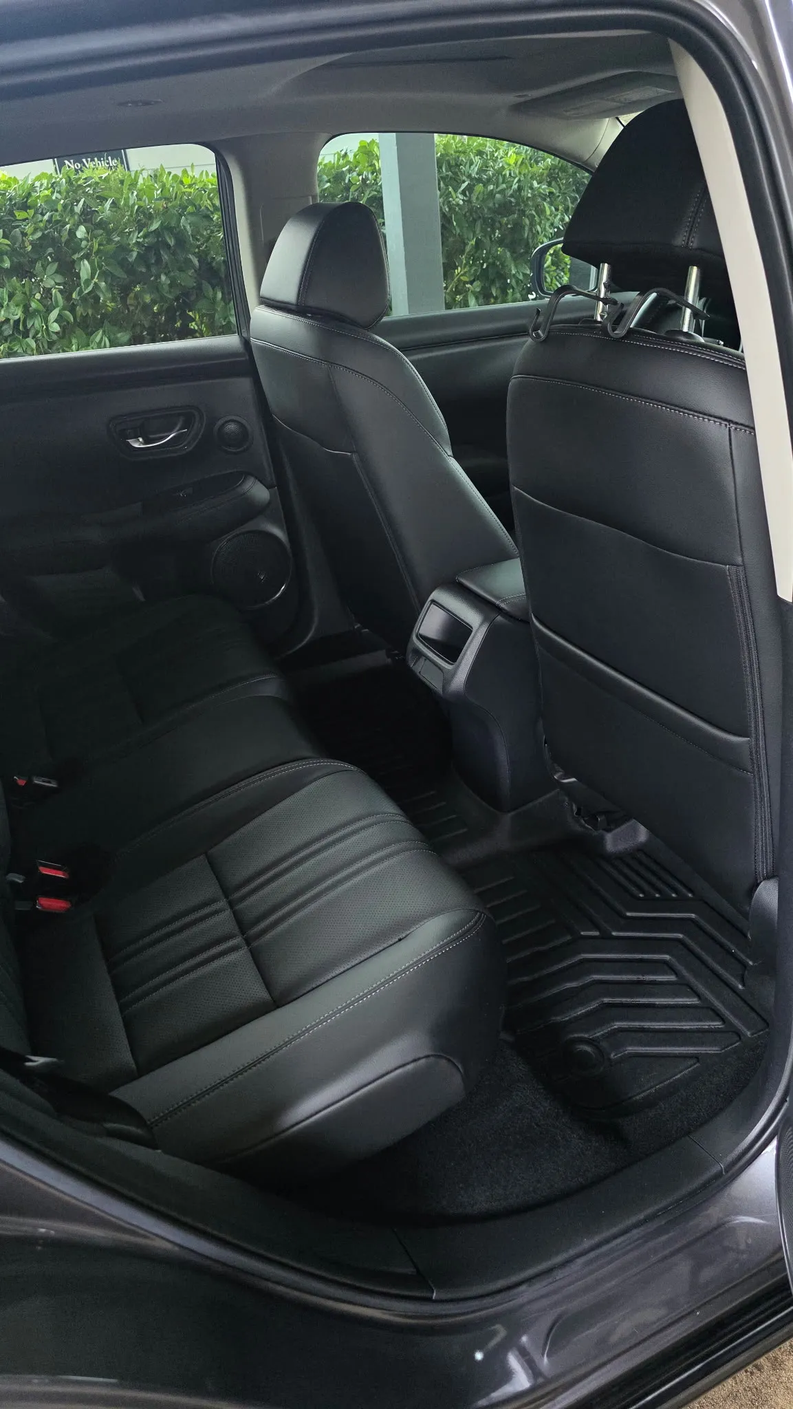 Rear seats of a grey crossover with clean black leather and floor mats
