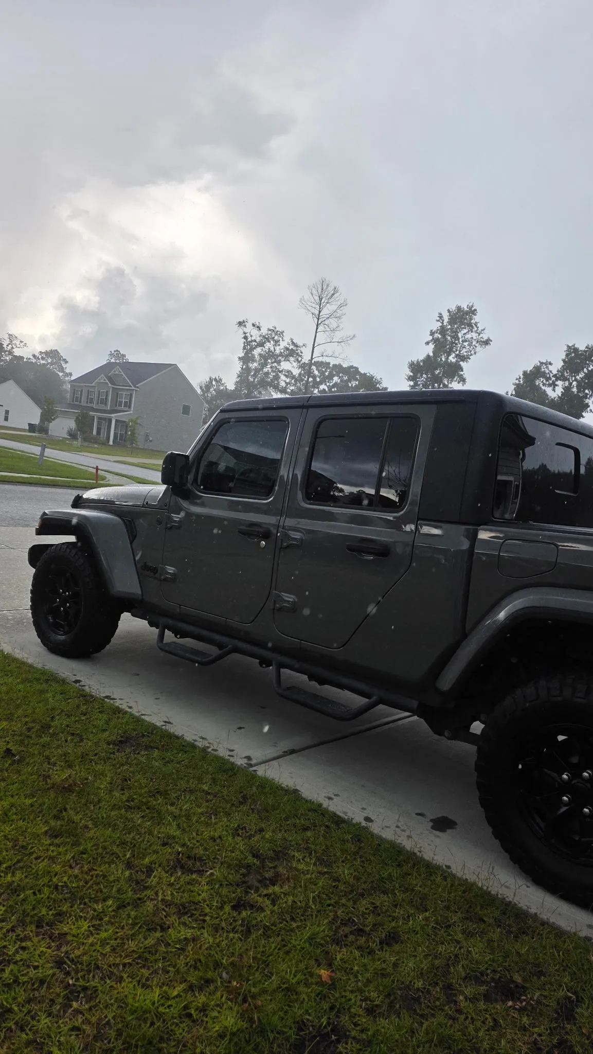 Grey Jeep Gladiator parked at the kerb with clean paint and wheels