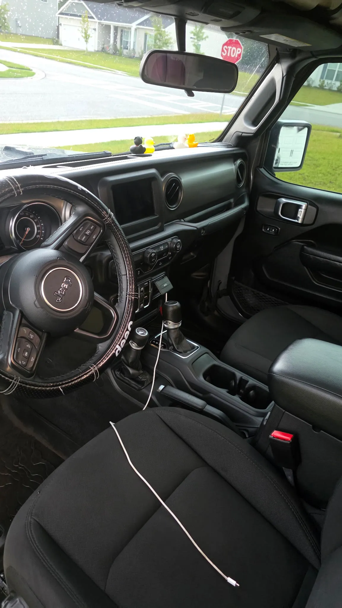 Front interior of a Jeep Gladiator with clean seats, steering wheel and console