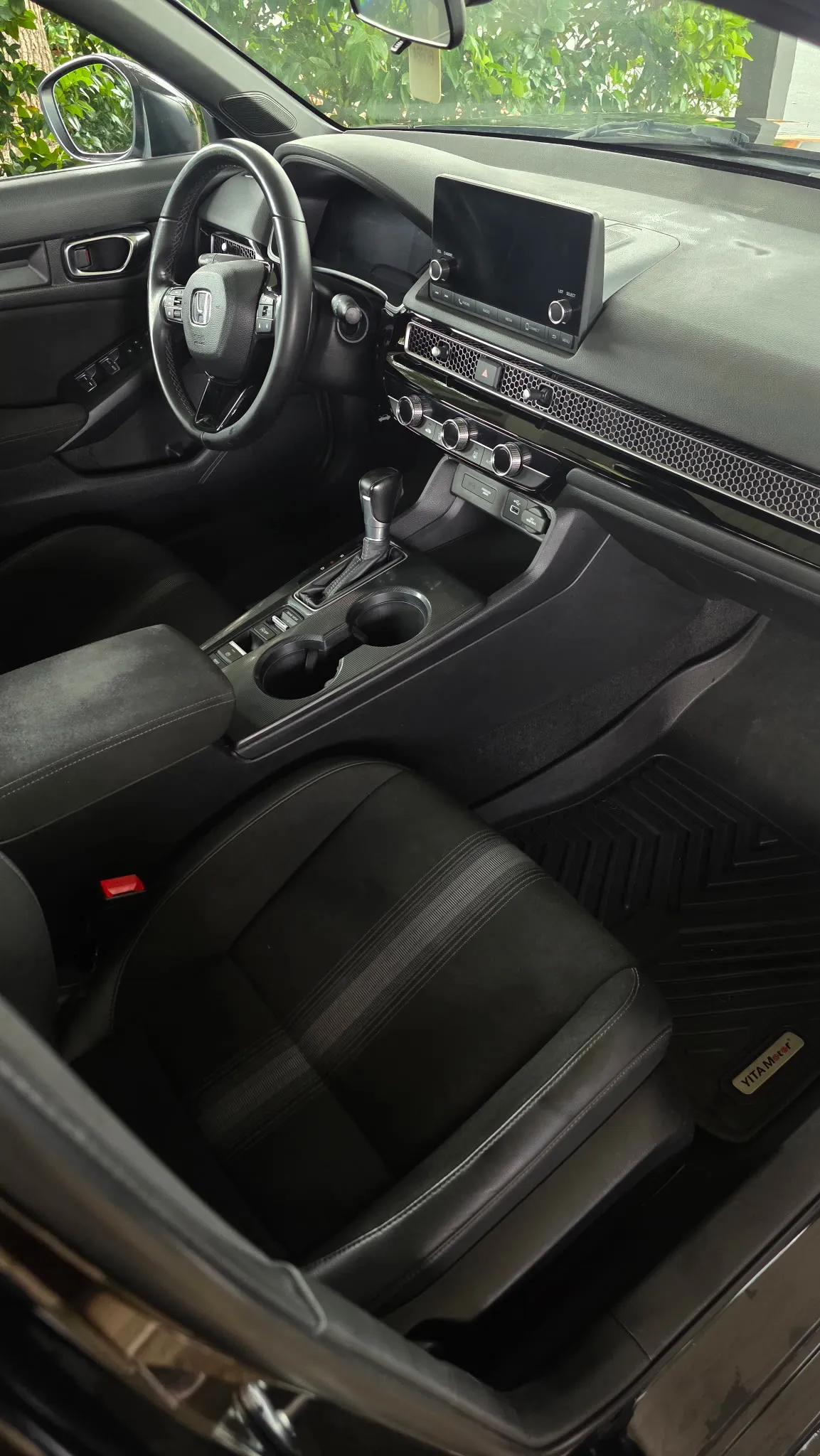Front interior of a sedan with clean black leather seats and centre console