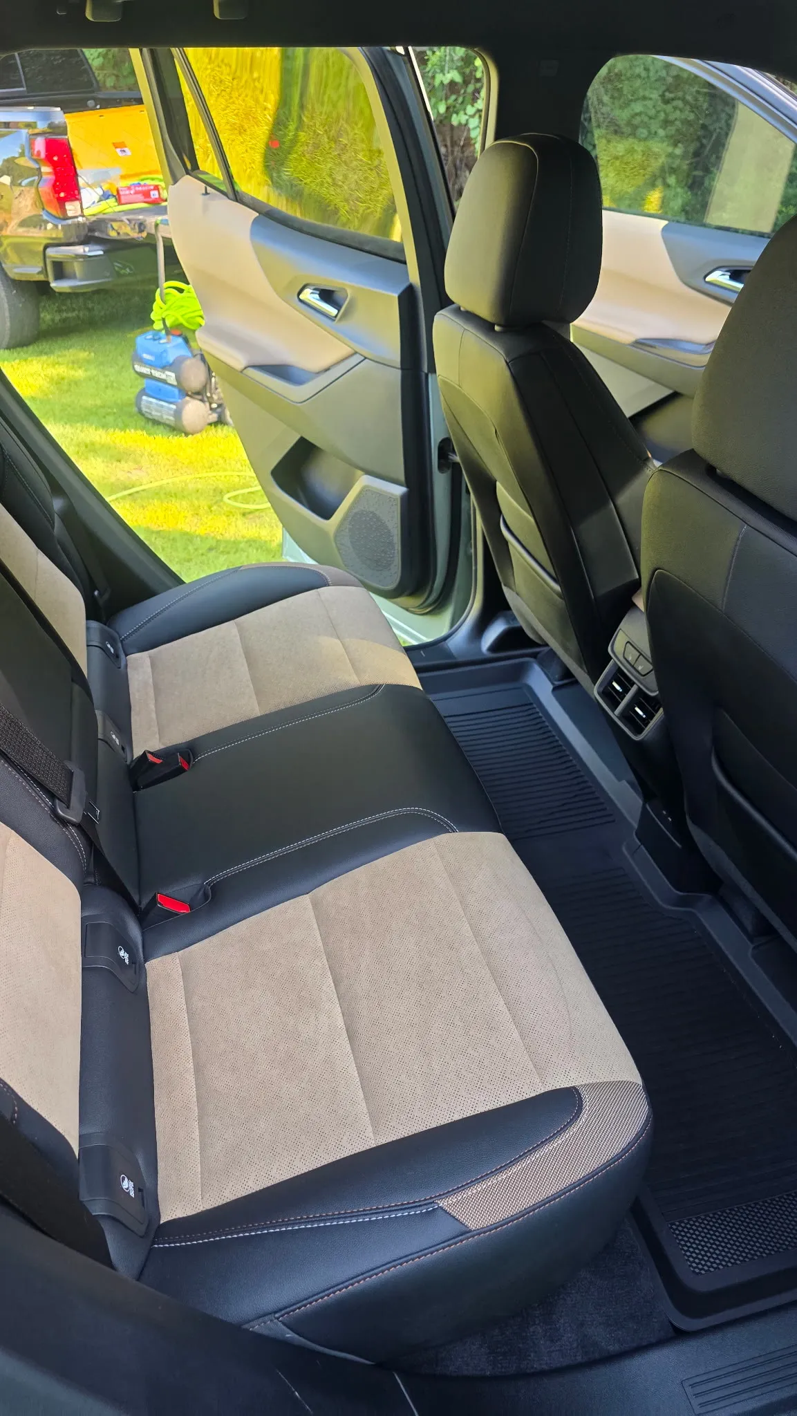 Rear bench seat of a sedan with clean tan cloth upholstery